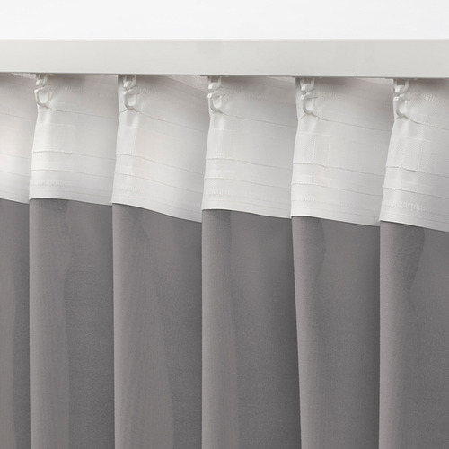 Cortinas blancas y grises con lengüetas para colgar, con tejido transparente diseñado para difuminar la luz.