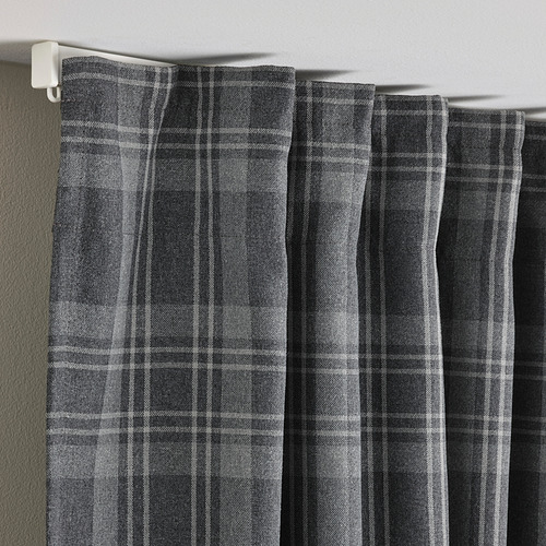 Cortinas de ventana de color gris oscuro con patrón de tartán colgando, mostrando tela que oscurece la habitación y característica de privacidad.