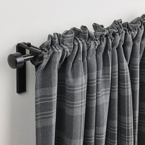 Las cortinas plisadas de color gris oscuro cuelgan de una varilla negra moderna y ajustable.