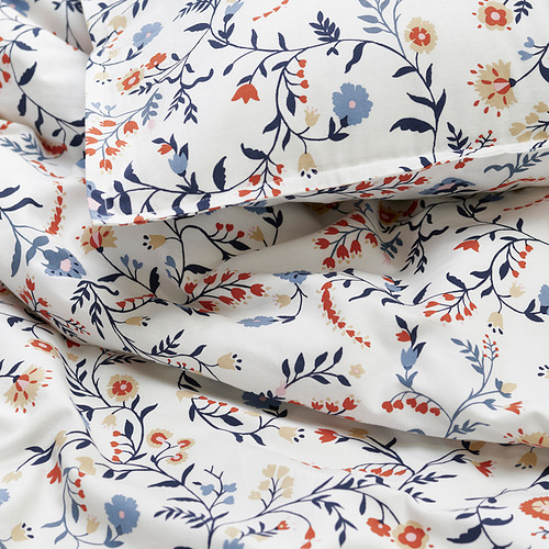Funda nórdica floral de suave algodón orgánico, con un detallado estampado de flores silvestres, cuidadosamente doblado, que resalta su textura de calidad.