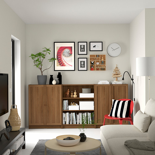 Sala de estar moderna con estantería BILLY, plantas, pared de galería, silla roja, sofá, mesa de centro, lámpara, tv.