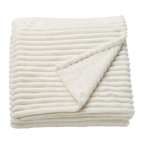 Una manta GULLSTRÅLE doblada en color blanco. Confeccionado en poliéster 100% reciclado, tiene un diseño de rayas suave y texturizado.