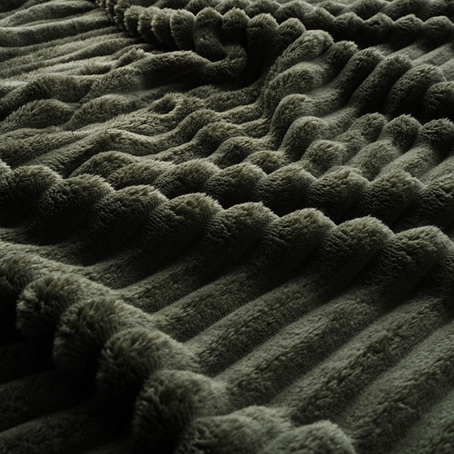 Manta verde, suave, afelpada en primer plano. Textura profunda, sensación lujosa.