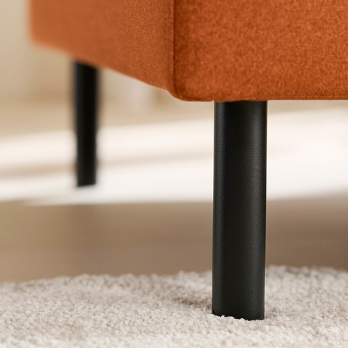 Primer plano de una pata tapizada naranja de un sofá, mostrando un soporte metálico resistente.