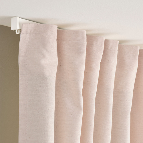 Cortinas de algodón rosa claro con ganchos visibles para colgar, drapeadas para mostrar textura y pliegues.