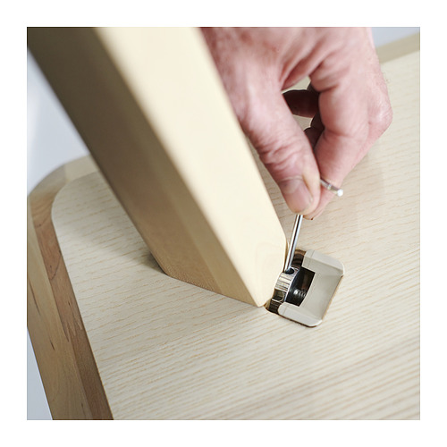 Persona montando muebles ligeros de madera.