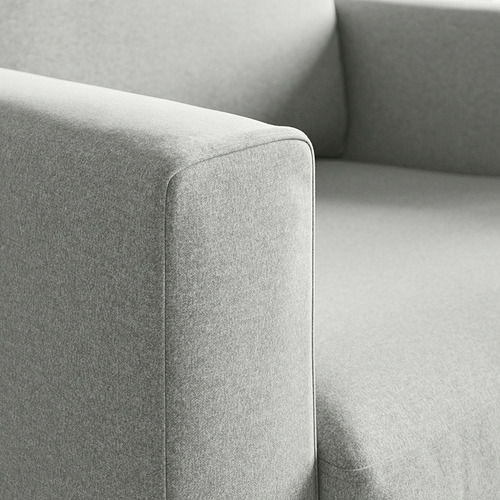 Primer plano de un sillón moderno tapizado, mostrando su tela suave y texturizada y sus costuras resistentes.