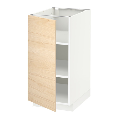 Un mueble blanco abierto con puerta de madera clara con estantes interiores, parte del sistema de cocina METOD.