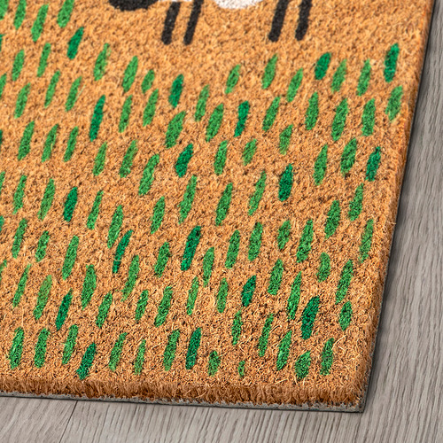 Felpudo natural de fibra de coco con patrón verde, duradero y ecológico, colocado sobre suelo de madera.