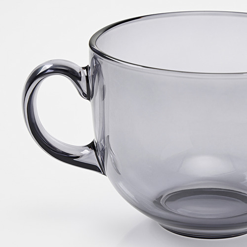 Una taza de cristal gris translúcido con un mango robusto, que muestra un diseño elegante y buena calidad.