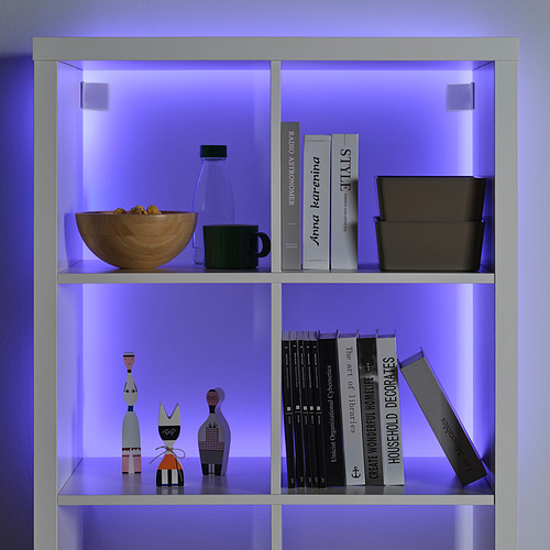 Estantería azul iluminada por LED, con cuenco, jarrón, taza, libros y decoración.