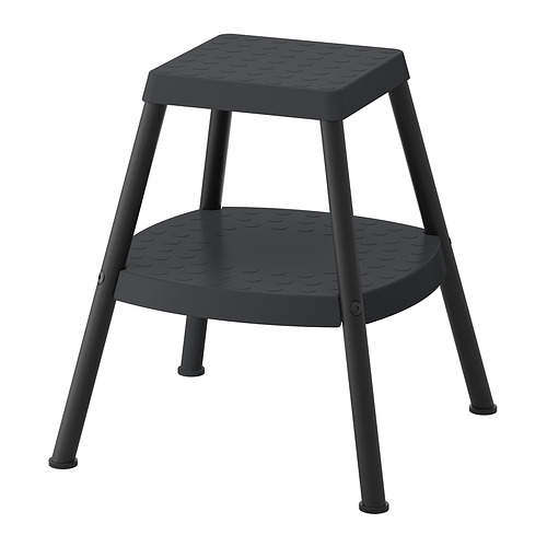 Taburete negro con asiento y patas de plástico, superficie texturizada para agarre, asiento cuadrado, diseñado para llegar a lugares altos.