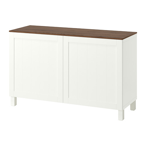 Un aparador blanco BESTÅ con tapa de madera. Tiene estantes ajustables, una opción de bisagra de apertura o cierre suave y patas resistentes. Diseño sencillo y funcional.