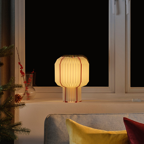 Lámpara STRÅLA: marfil con líneas rojas, resplandor cálido, decoración festiva.