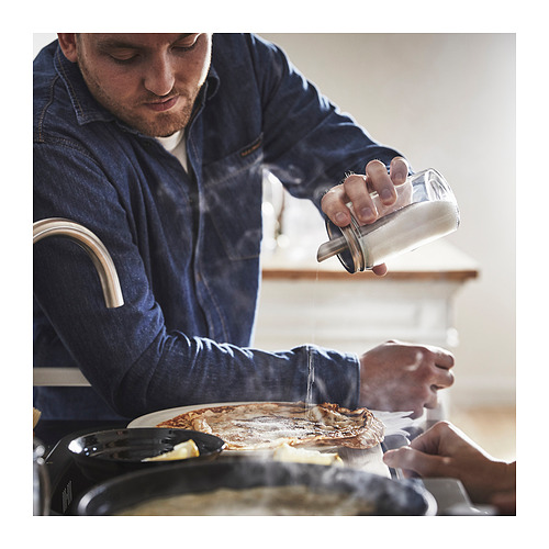 El hombre agita el azúcar de CITRONHAJ, recipiente transparente, tapa de acero inoxidable, sobre la comida.