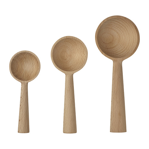 Tres cucharas de madera, de color marrón claro, de tamaño variable, colocadas una al lado de la otra, con diseños suaves y curvos.