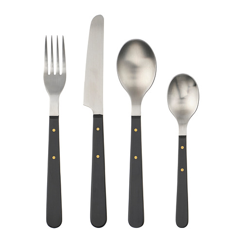 Cubertería DOFTSKÖLD de cuatro piezas engastada en negro con detalles dorados, con asas de acero inoxidable y diseño clásico.