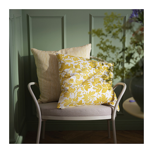 Dos cojines amarillos brillantes y blancos sobre una silla blanca, uno con patrones florales y el otro a rayas.