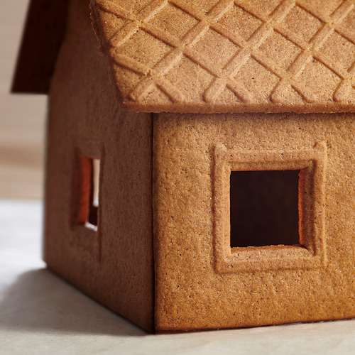 Mini casa de jengibre modelo, marrón, techo texturizado, ventanas cuadradas.