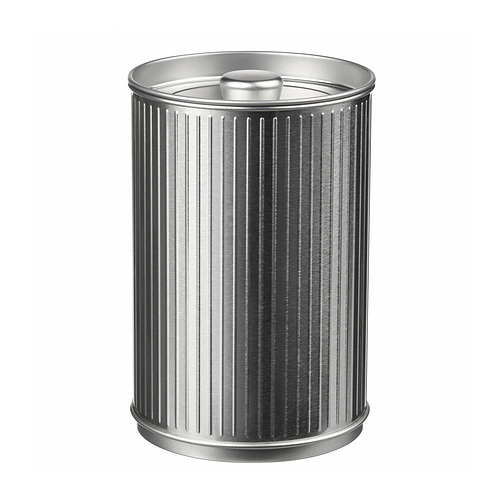 Un bote de basura cilíndrico de color plateado. Tiene patrones verticales y estriados y una tapa redondeada. El diseño es de metal con un acabado brillante y pulido.