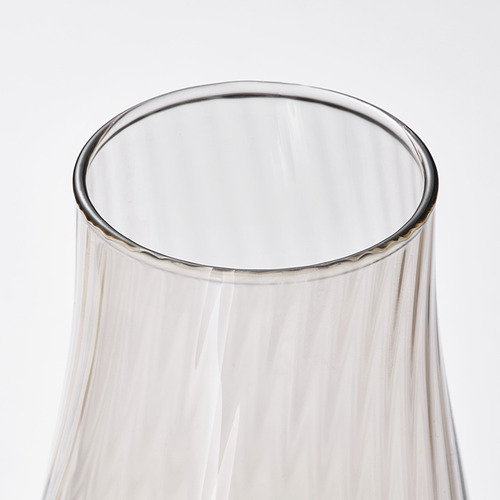 Jarrón de vidrio transparente con patrones arremolinados en el interior, que capturan la luz y muestran una belleza elegante y reflectante.