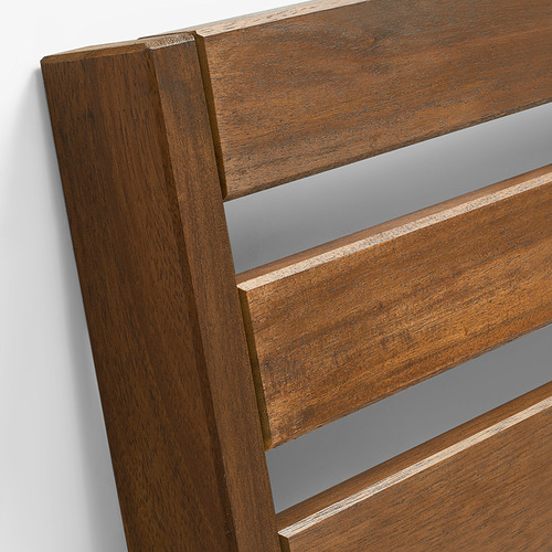 Primer plano de muebles de exterior de madera resistentes. Elaborado con madera de acacia oscura y pulida, que destaca su veta natural y durabilidad para un uso duradero.