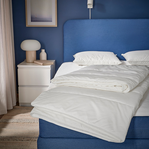 Edredón nórdico SKOGSFRÄKEN blanco sobre cama moderna con ropa de cama azul.