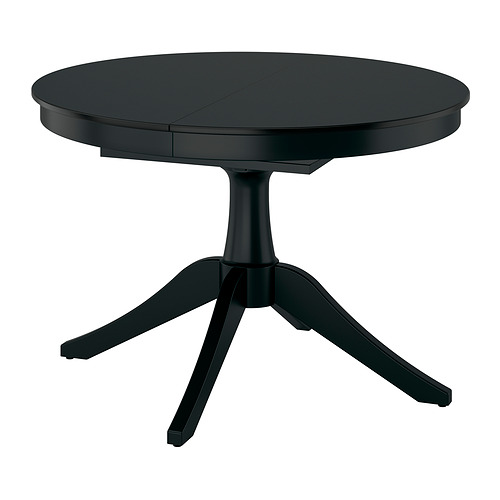 Mesa de comedor extensible negra con tapa redonda y base de pedestal, capacidad para seis personas.