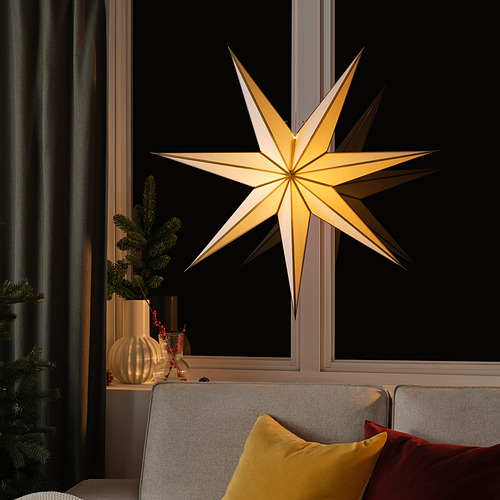 Acogedora sala de estar con lámpara de estrella, sofá y decoración festiva.
