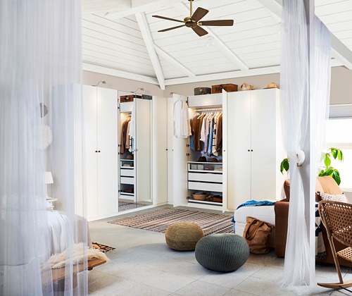 Dormitorio amplio y luminoso con puertas de armario FORSAND blancas, con un diseño minimalista, cestas de almacenamiento y un ventilador de techo.