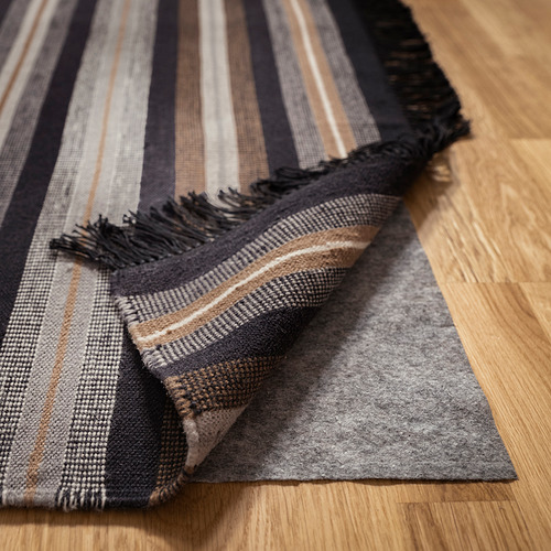 Alfombra de lana a rayas sobre suelo de madera, reversible, tejida a mano, trama plana.