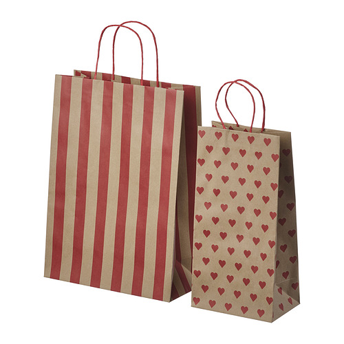 Dos bolsas de papel marrón, una a rayas rojas, otra con corazones rojos, ambas con asas rojas.