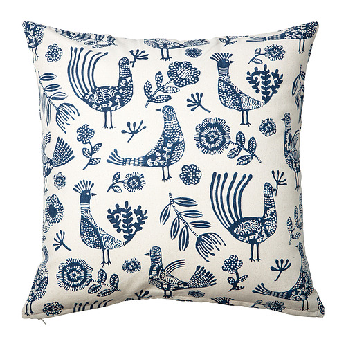 Cojín KRUTBRÄNNARE, neutro con estampado azul, cuadrado, floral y pájaro, confeccionado en algodón.
