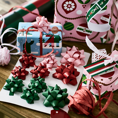 Surtido de coloridos lazos de regalo en varios tamaños, rojo y verde, exhibidos en papel blanco, listos para envolver para regalo.