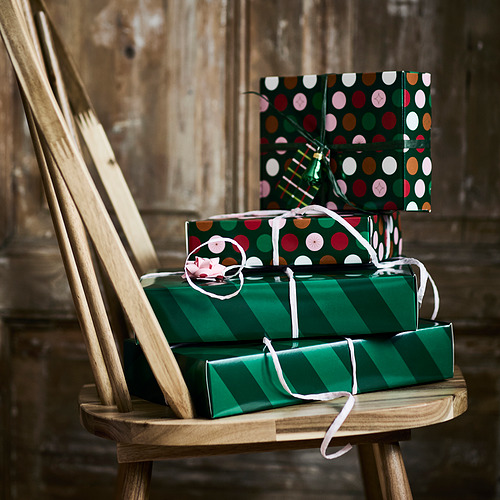 Dos cajas de regalo festivas apiladas en una silla de madera, listas para los regalos de Navidad.