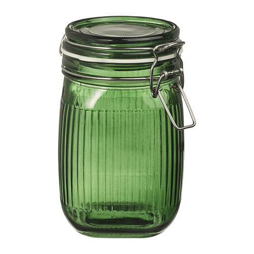 Tarro de cristal verde con tapa de cierre metálico, diseño acanalado. Compacto, forma cilíndrica, cierre hermético.