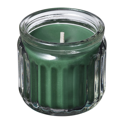 Vela verde en tarro de cristal transparente con diseño acanalado, mecha blanca.