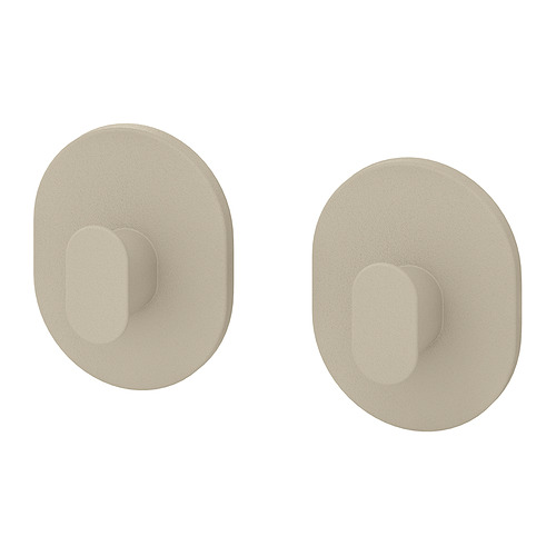 Dos ganchos de pared circulares de color beige con huecos rectangulares. Diseño sencillo y moderno, ideal para colgar artículos.