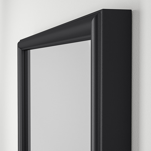 Espejo rectangular negro con marco ancho montado en la pared.