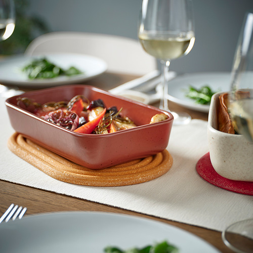 Configuración de la cena con soporte de bambú, plato, verduras, vaso y platos.
