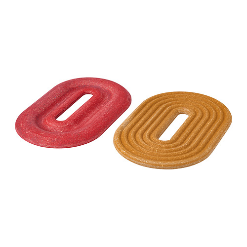 Dos salvamanteles de colores brillantes; uno rojo, otro dorado. Formas ovaladas con recortes, hechas de bambú comprimido.