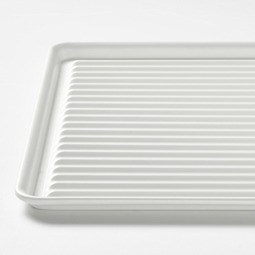 Escurridor de platos de acero elegante y duradero con ranuras elevadas para un secado eficiente. Los bordes altos contienen agua, el acabado lacado es fácil de limpiar.