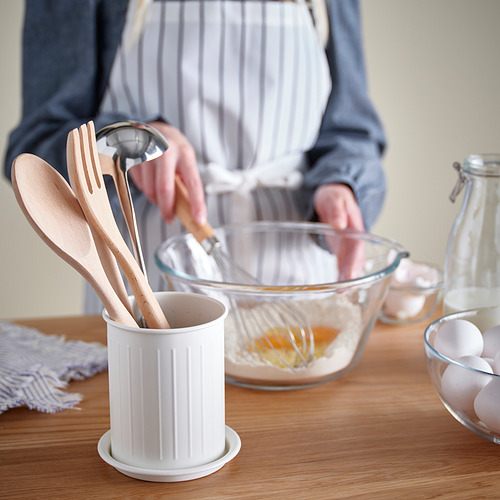 Persona cocinando con utensilios de madera y cuenco de cristal.