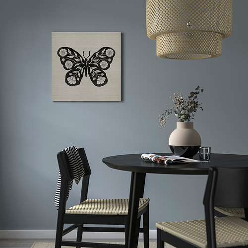 Habitación moderna con arte de mariposas en blanco y negro, mesa oscura, plantas y luz colgante.