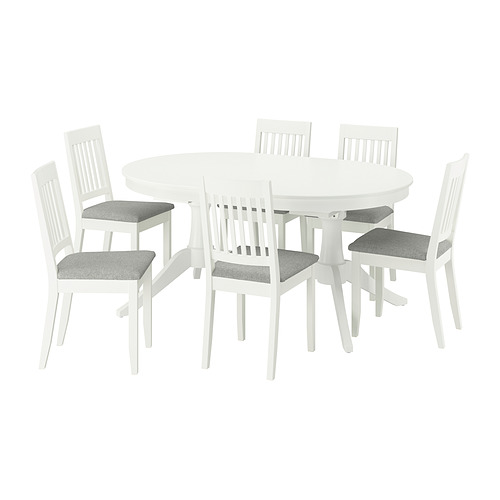 Juego de comedor ROSENTORP blanco: mesa ovalada, 6 sillas. Las sillas tienen cojines grises, respaldos de madera. La mesa se extiende para más asientos.
