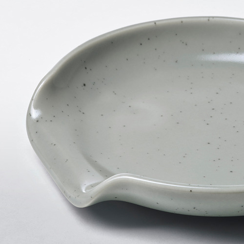 Pequeño portacucharas de gres gris claro con un sutil patrón moteado, diseñado para evitar derrames de utensilios de cocina.
