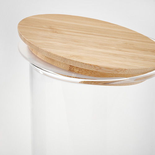 Primer plano de un elegante frasco de vidrio con tapa de madera, que muestra materiales y diseño de calidad.