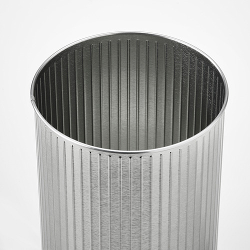 Cubo de basura cilíndrico plateado con ranuras verticales, diseño elegante, acabado metálico.