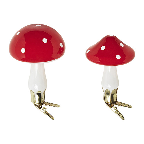 Dos adornos navideños rojos brillantes en forma de hongo con manchas blancas y clips dorados para colgar.