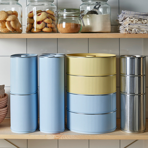 Coloridas latas apilables con tapas en un estante de madera, que almacenan alimentos.
